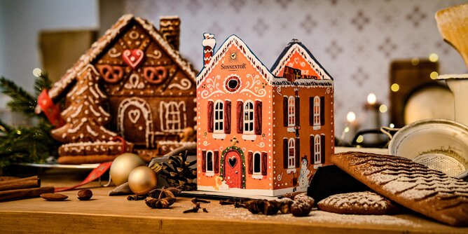 Foto von einem echtem Lebkuchenhaus und einem gebasteltem Lebkuchenhaus aus dem Gewürzadventkalender. | © SONNENTOR