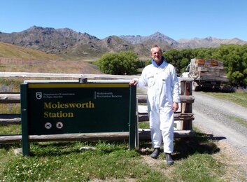 In the photo you can see a beekeeper next to the sign of the nature reserve molesworth station. | © SONNENTOR