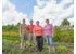 The photo shows four farmers in a field.