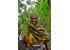 A photo of a woman holding a cardamom plant in her hand.