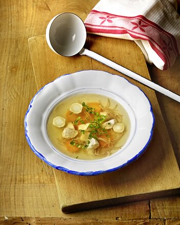 Au dem Foto ist ein Suppenteller mit Gute Laune Hühnersuppe zu sehen. Darin sieht man Wurzelgemüse und Hühnchen Fleisch. | © SONNENTOR