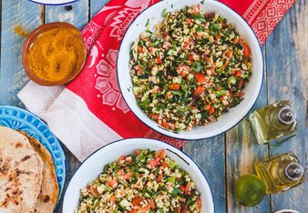 Auf dem Foto sind zwei Schüsseln mit Bulgur zu sehen. Daneben sind Öle, Fladenbrot und zahlreiche Gewürze zu sehen. | © SONNENTOR