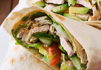 Auf dem Foto sieht man gefüllte Hühnerwraps. Im Wrap sieht man auch Avocado, Rucola, Sprossen und Tomaten. | © SONNENTOR