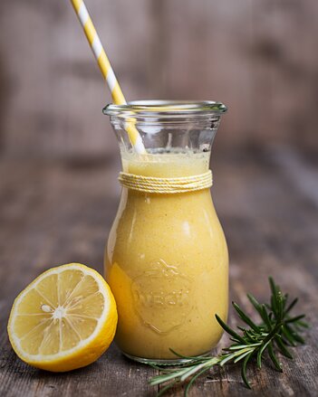 Auf dem Foto ist eine Karaffe mit Kurkuma Detox Smoothie zu sehen. Daneben sieht man eine halbe Zitronenscheibe. | © SONNENTOR