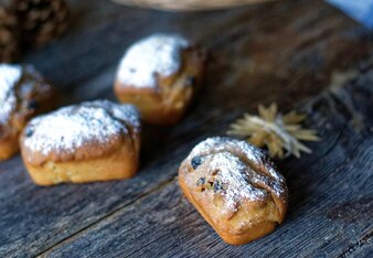 Auf dem Foto sieht man Mini-Gewürzstollen. Im Hintergrund ist ein Korb mit einem blauen Tuch zu sehen. | © SONNENTOR