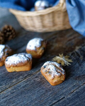 Auf dem Foto sieht man Mini-Gewürzstollen. Im Hintergrund ist ein Korb mit einem blauen Tuch zu sehen. | © SONNENTOR