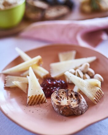 Auf dem Foto ist ein Teller zu sehen, auf dem in der Mitte Himbeerchutney und rundherum Käsestücke platziert sind.  | © SONNENTOR