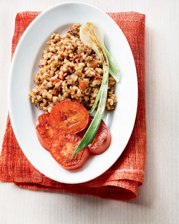 Auf dem Foto ist ein Teller mit Risotto zu sehen. Daneben sind Tomatenscheiben und Fenchel zu sehen. | © SONNENTOR