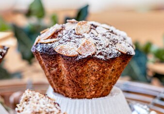 Auf dem Foto sieht man einen orientalischen Zucchini Muffin auf einer umgedrehten Muffinform stehen. Der Muffin ist mit Staubzucker bestäubt. | © SONNENTOR