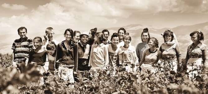 The black and white photo shows many people in a field in Albania. | © SONNENTOR