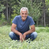 The photo shows a man in a field in Greece. | © SONNENTOR