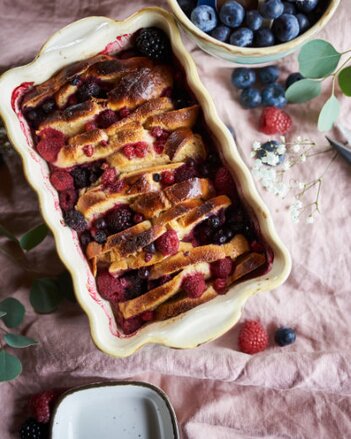 Auf dem Foto ist der Scheiterhaufen mit bunten Beeren zu sehen. Daneben steht eine Schale mit frischen Heidelbeeren. | © SONNENTOR