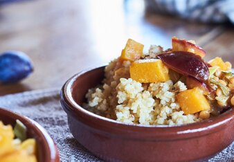 Auf dem Foto ist eine Form mit Tajine mit Kürbis und Zwetschken zu sehen. Die Form steht auf einem blauen Tuch. | © SONNENTOR