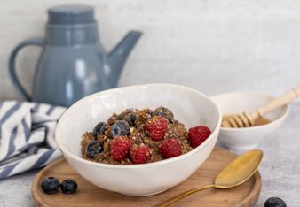 Auf dem Foto ist eine Schale mit Vanille-Beeren Porridge zu sehen. Das Porridge ist mit frischen Früchten garniert. | © SONNENTOR