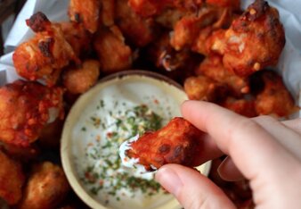 Auf dem Foto sind viele rote Karfiol Wings zu sehen. In der Mitte steht eine Schüssel mit Dip. | © SONNENTOR