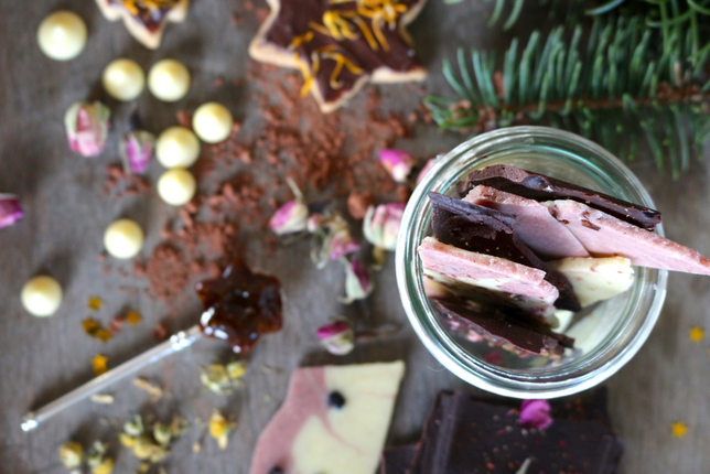 Auf dem Foto sieht man ein Glas mit veganer Spicy Gewürz-Schoko in heller, rosa und dunkler Farbe. | © SONNENTOR