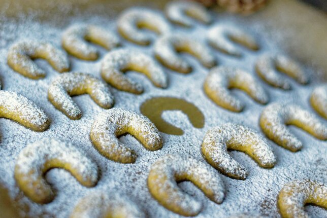 Auf dem Foto ist ein Blech mit Vanille-Kurkuma Kekse zu sehen. Sie sind mit Staubzucker übersehen. | © SONNENTOR