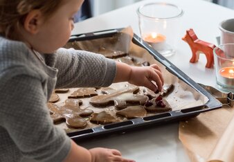 Auf dem Foto sieht man wie ein Kind Lebkuchen mit Rosinen verfeinert. | © SONNENTOR