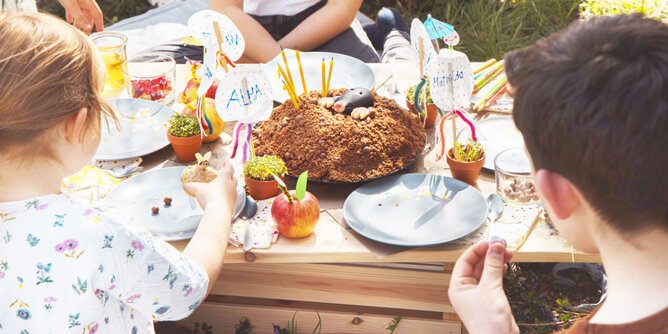 Auf dem Foto sieht man mehrere Kinder bei Tisch sitzen. Darauf steht ein Maulwurfkuchen. | © SONNENTOR