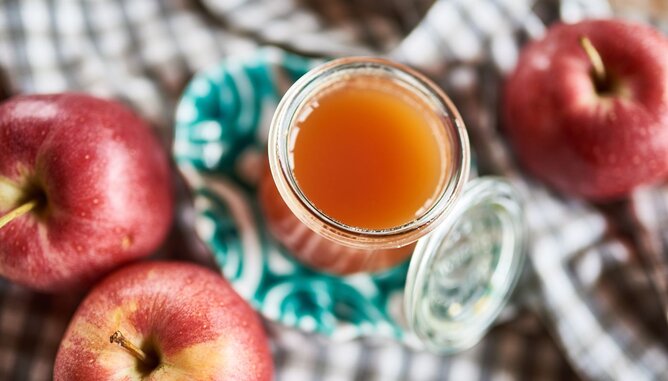 Auf dem Foto ist ein Glas mit Apfelmarmelade zu sehen. Daneben liegen frische Äpfel. | © SONNENTOR