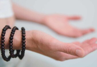 Auf dem Foto sieht man die Hände einer Frau mit den Handflächen nach oben gerichtet. Sie trägt drei Armbänder aus Holzkugeln. | © SONNENTOR