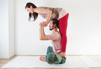 Auf dem Foto sieht man die Yoga Partnerübung Schmetterling. | © SONNENTOR